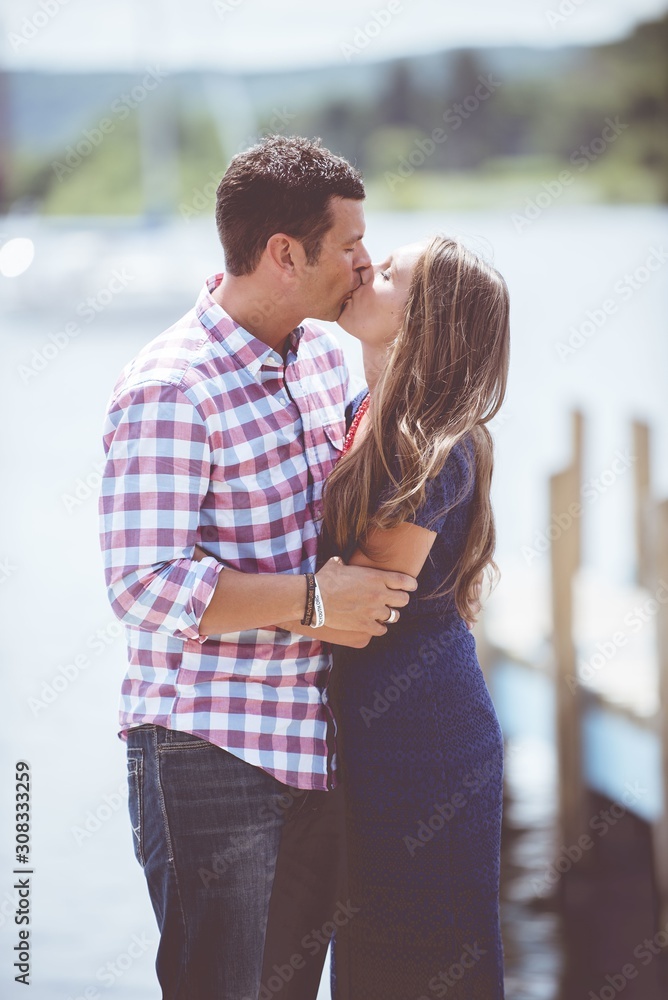 Poster Vertical shot of a romantic couple kissing each other