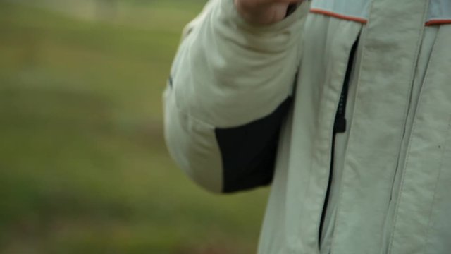 Hand with device of vaping young man in the park in the evening