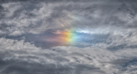 colorful rainbow sundog in the clouds