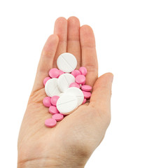 multicolored tablets of different size in hand top view close-up macro, isolated, white background