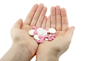 multicolored tablets of different size in hand top view close-up macro, isolated, white background