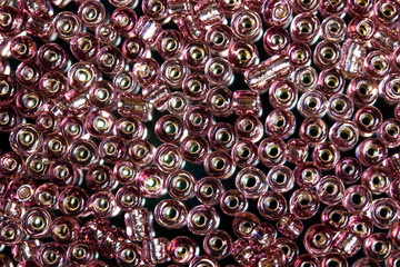 pile of  aubergine colored Rocaille transparent glass beads 