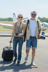 happy couple walking out a near private airplane