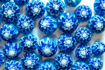 Blue white beads with stars on a white sheet. 
