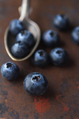 Fresh blackberry in a teaspoon on a rough surface