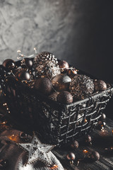 vintage christmas, new Year toys and decoration in basket on brown wooden table with garlands