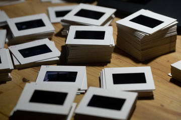 piles of 35mm slides on a wooden table