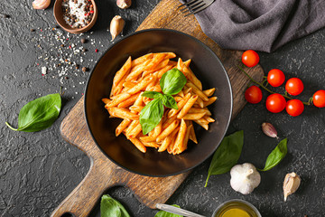 Plate with tasty pasta on dark background
