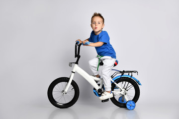 young boy happily riding on a bicycle on isolated background