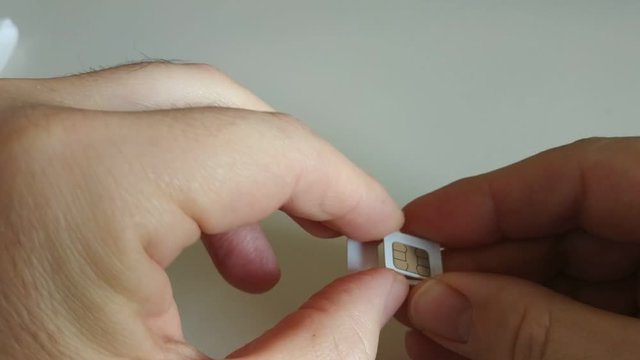 Turin, Piedmont, Italy.December 2019. Close-up shot of a SIM of the mobile network operator. The hands of a Caucasian man unplug the sim from the plastic frame for the sim formats, micro sim, nano sim