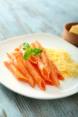 Plate with tasty pasta with cheese on wooden table