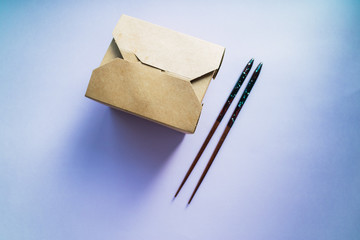 Takeaway asian food on compostable delivery box and chopsticks.