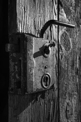 Old antique door handle on wooden door. Black and white photography