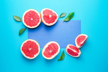 Fresh cut grapefruit and blank card on color background