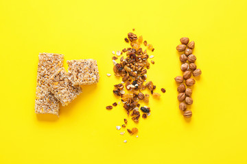 Tasty granola bars with ingredients on color background