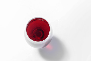 Glass with tasty wine on white background, top view