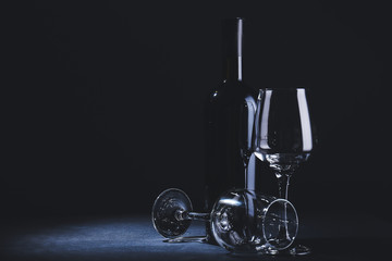 Bottle of wine with glasses on dark background