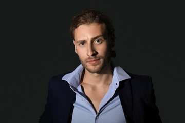 Portrait of handsome businessman on dark background