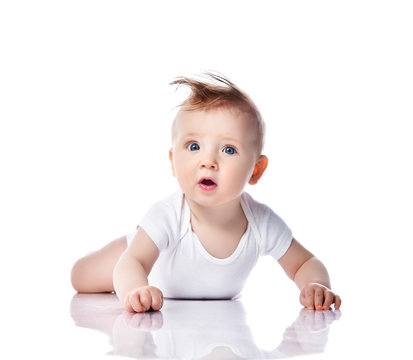 Infant child baby boy kid with blue eyes happy smiling screaming lying on a floor isolated on a white background