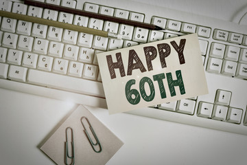 Conceptual hand writing showing Happy 60Th. Concept meaning a joyful occasion for special event to mark the 60th year White keyboard with note paper and clips on white background