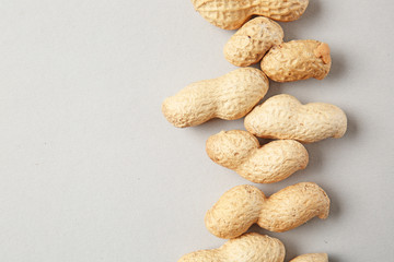 Fototapeta na wymiar Tasty peanuts on light background