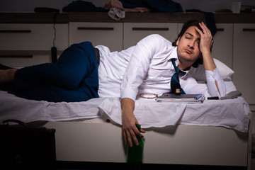 Young employee working at home after night shift