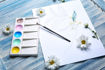 Set of artist's supplies and drawing on wooden background