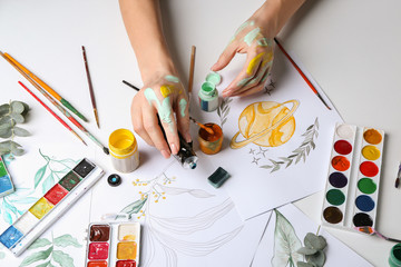 Artist painting picture at table
