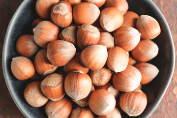 Plate with tasty hazelnuts, top view