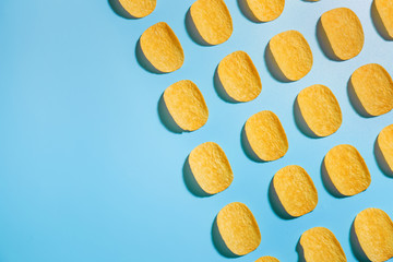 Tasty potato chips on color background