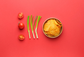 Obraz na płótnie Canvas Tasty potato chips, tomatoes and green onion on color background