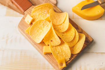 Tasty potato chips with cheese on table