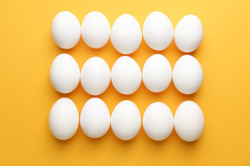 Fresh raw eggs on color background