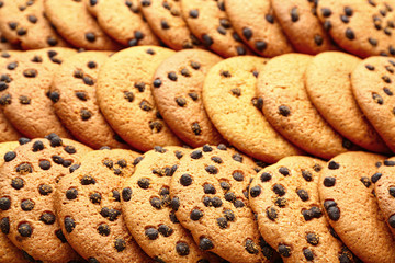 Many tasty cookies with chocolate chips as background