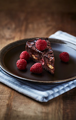 Piece of Chocolate Cake on plate. Rustic wooden background.