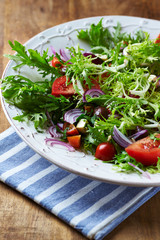 Salad with Olives, Tomatoes, Endive   and Red Onion. Healthy Snack Idea. Rustic wooden background. 