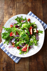 Salad with Olives, Tomatoes, Endive   and Red Onion. Healthy Snack Idea. Rustic wooden background. Top view. 