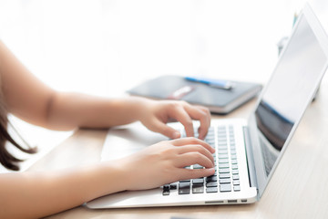 Closeup freelance asian woman working and typing on laptop computer at desk office with professional, girl using notebook checking email or social network, business and lifestyle concept.