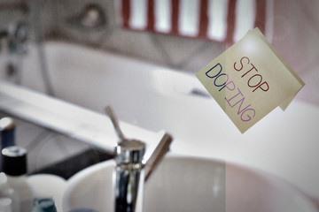 Word writing text Stop Doping. Business photo showcasing do not use use banned athletic perforanalysisce enhancing drugs Piece of square yellow sheet use to give notation stick to washroom mirror