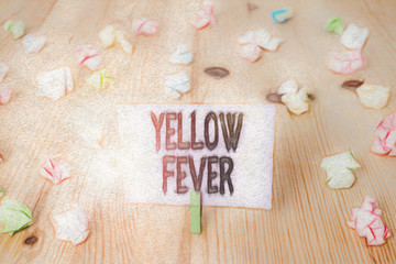 Fototapeta na wymiar Writing note showing Yellow Fever. Business concept for tropical virus disease affecting the liver and kidneys Colored crumpled papers wooden floor background clothespin