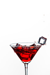 Closeup of Icecubes in Colorful Liquid. Falling to Goblet with Droplets. Against White Background.