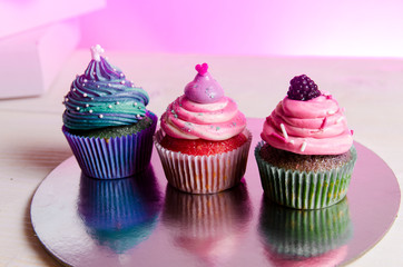 Three colorful cupcakes with delicious frosting 