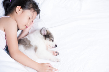 Children sleep in bed with her puppy