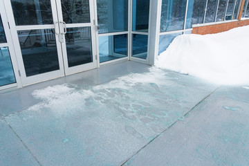 Melting salt and ice in front of entrance gate office building