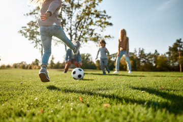 Where family fun begins. Happy family playing with a ball on meadow