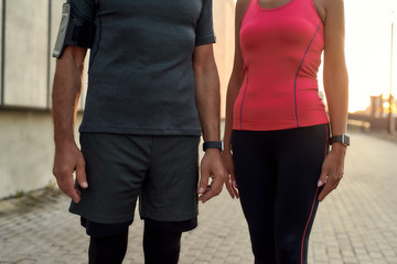 Cropped photo of a couple in sports clothing standing together outdoors