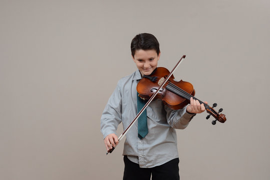 Boy playing viola wearing shirt and tie