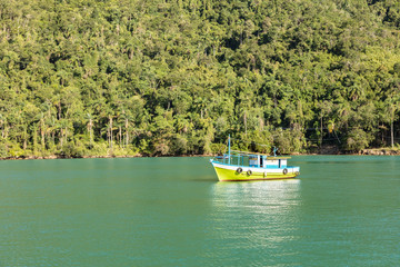 Boat in big island (Ilha Grande), sea of Angra dos Reis bay with beautiful large mountains in the background, beach holidays on the coast of Rio de Janeiro, Brazil