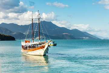 Schooner in big island (Ilha Grande), sea of Angra dos Reis bay with beautiful large mountains in...