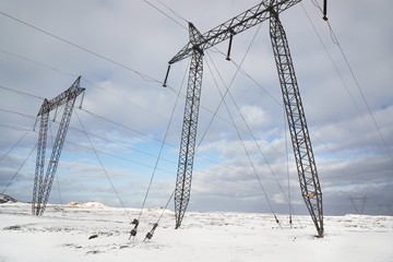 Electric lines through the rugged snowy landscpe if Iceland